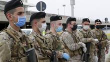 I soldati libanesi, con indosso equipaggiamento protettivo, fanno la guardia all'aeroporto internazionale di Beirut il 5 aprile, prima del ritorno dei cittadini di ritorno.