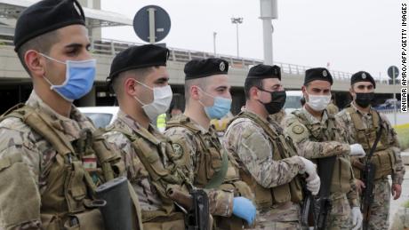 I soldati libanesi, con indosso equipaggiamento protettivo, fanno la guardia all'aeroporto internazionale di Beirut il 5 aprile, prima del ritorno dei cittadini di ritorno.