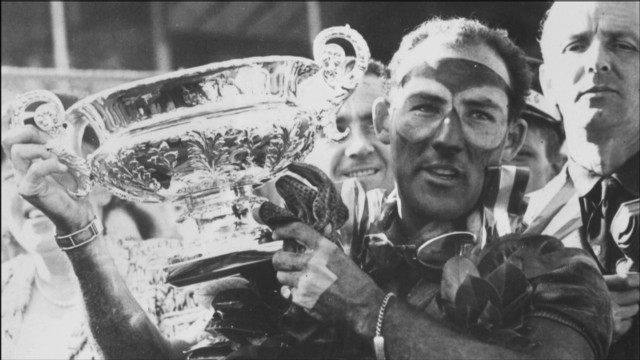 Stirling Moss solleva il trofeo al Gran Premio di Gran Bretagna nel 1955.
