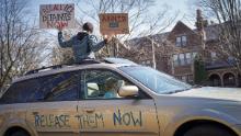 Attivisti che sono rimasti principalmente nelle loro auto per suonare il clacson a distanza sociale fuori dalla residenza del governatore a St. Paul, Minnesota, il 27 marzo.