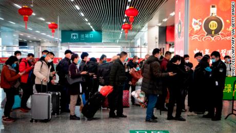 I passeggeri mascherati fanno la fila per mostrare un codice QR verde sui loro telefoni di sicurezza all'arrivo alla stazione di Wenzhou a Wenzhou.