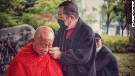 Un uomo si è fatto tagliare i capelli da un barbiere all'aperto in un parco a Wuhan il 23 aprile.