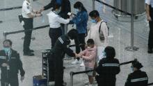 I passeggeri ricevono i braccialetti di localizzazione in quarantena all'aeroporto internazionale di Hong Kong il 19 marzo.