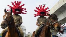 La polizia che indossa elmetti a tema coronavirus cavalca cavalli mentre partecipano a una campagna di sensibilizzazione a Secunderabad, la città gemella di Hyderabad, il 2 aprile 2022. 