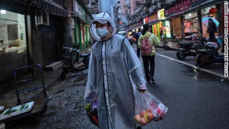 Una persona che indossa una maschera facciale come misura preventiva contro la diffusione del nuovo coronavirus COVID-19 sta trasportando generi alimentari in un distretto di Wuhan, nella provincia centrale di Hubei, in Cina, il 20 aprile.