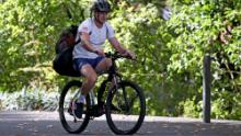 Il giocatore di rugby neozelandese Beauden Barrett arriva sulla sua bici per esercitarsi a calciare in isolamento.