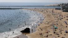 Le persone si vedono radunarsi su Corona del Mar State Beach il 25 aprile 2022 a Newport Beach, in California.