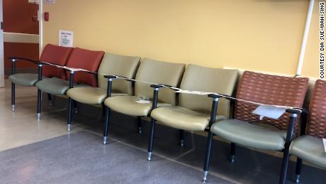Una fila di sedili in una sala d'attesa dell'ospedale viene registrata in modo che i pazienti non siedano lì. È una misura della distanza sociale che altri operatori sanitari hanno preso. 