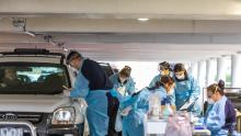 Professionisti medici che eseguono test per Covid-19 presso una struttura di prova al volante di un parcheggio il 30 aprile a Melbourne, in Australia. 