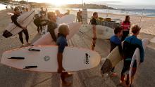 I surfisti stanno aspettando che i funzionari aprano Bondi Beach a Sydney il 28 aprile mentre le restrizioni contro la pandemia di coronavirus sono allentate. La spiaggia è aperta a nuotatori e surfisti per soli esercizi. 