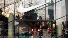 Un pedone che cammina attraverso un negozio Nike a Shanghai a marzo.