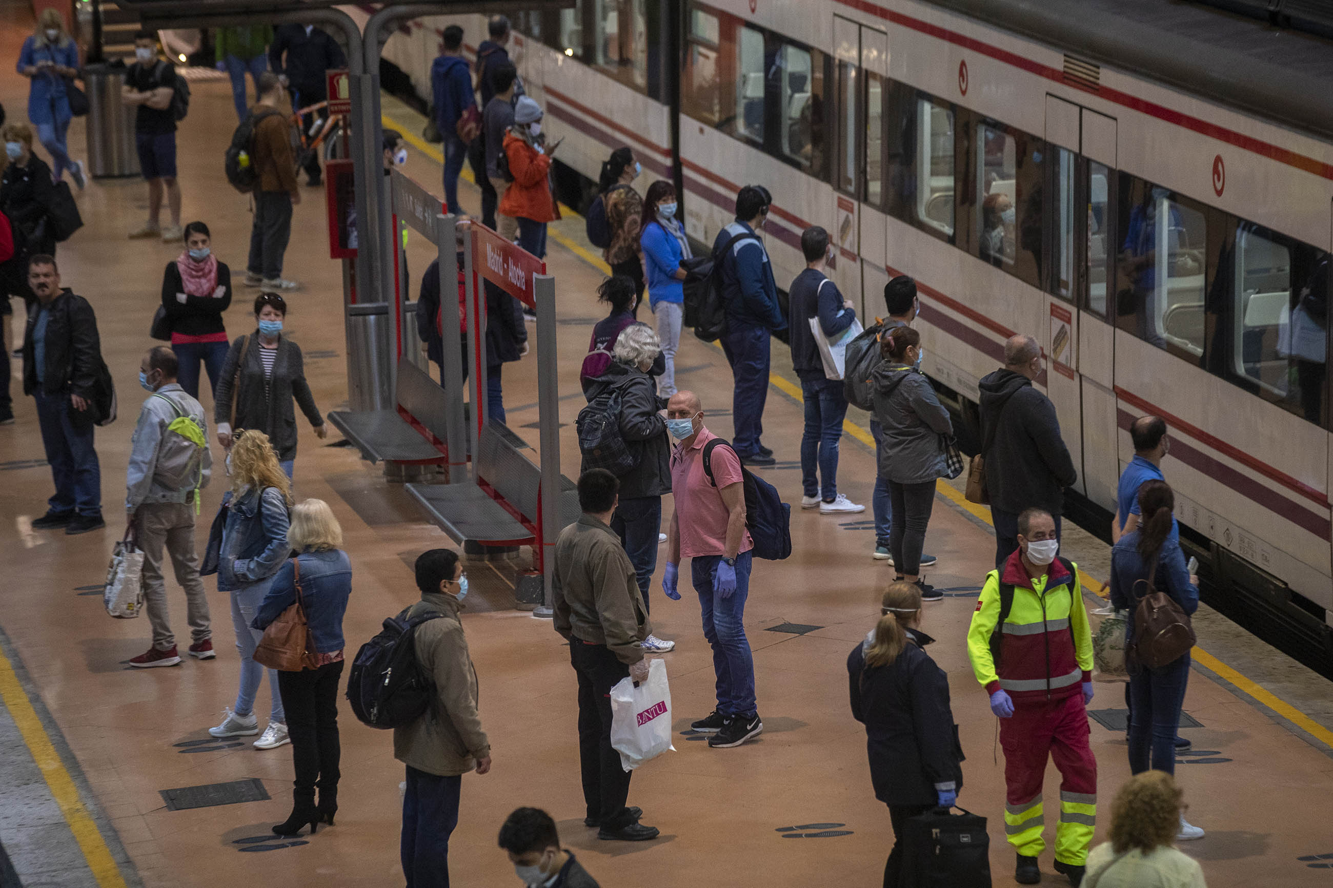 I pendolari indossano maschere per proteggersi dai coronavirus su una piattaforma presso la stazione di Atocha a Madrid, Spagna, lunedì 4 maggio. 