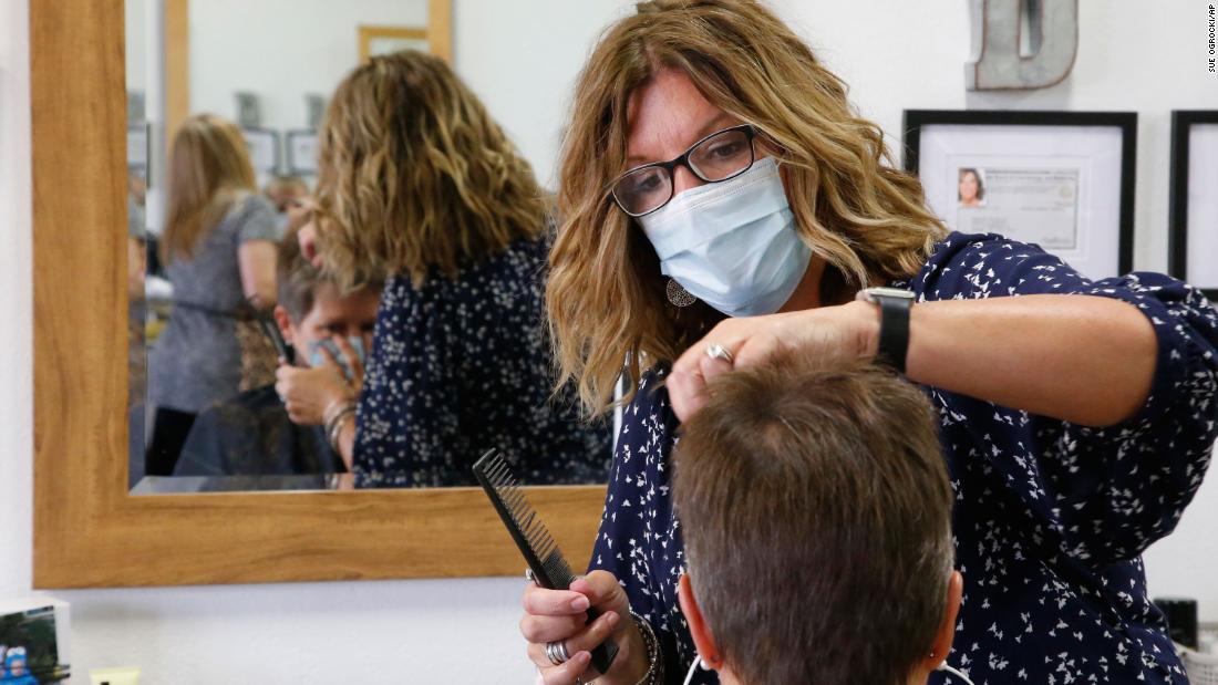 Denise Gravitt, top, cuts the hair of client Lisa Murray, bottom, at her salon, Beehive Salon, Friday, May 1, 2022, in Edmond, Okla., the first day hair salons have been allowed to reopen in Edmond following shutdowns due to coronavirus concerns.
