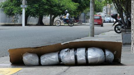 Un corpo abbandonato avvolto in plastica e coperto di cartone poggia su un marciapiede a Guayaquil, Ecuador, il 6 aprile.