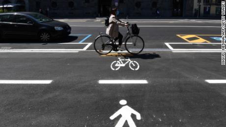 Una donna percorre una pista ciclabile a Milano.