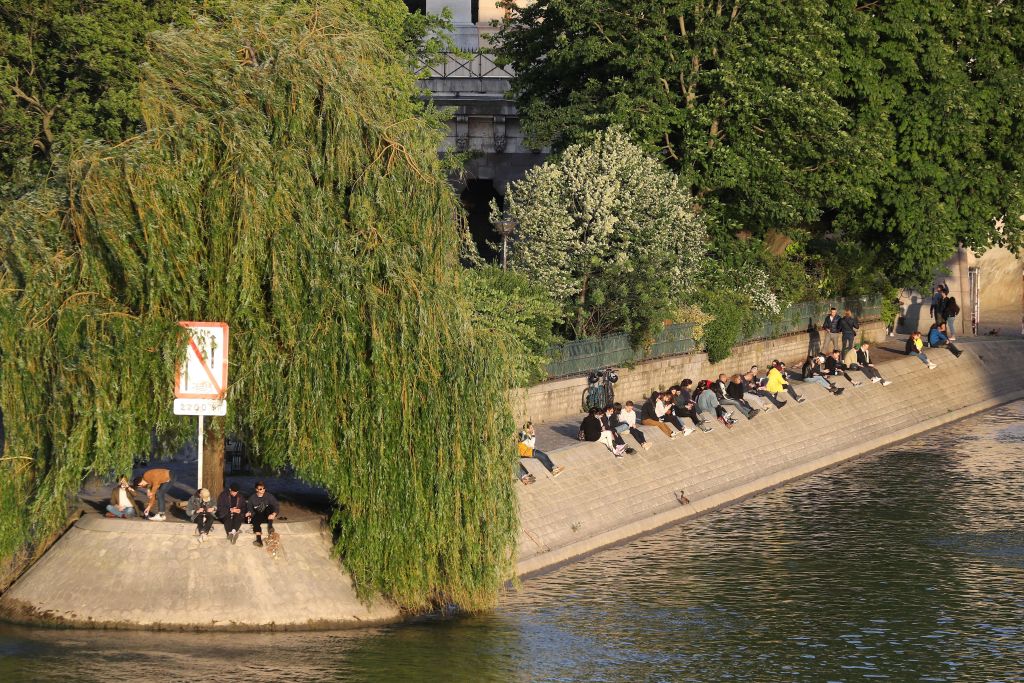 Le persone condividono un drink sulle rive della Senna a Parigi lunedì, il primo giorno dell'allentamento delle misure di preclusione in Francia.