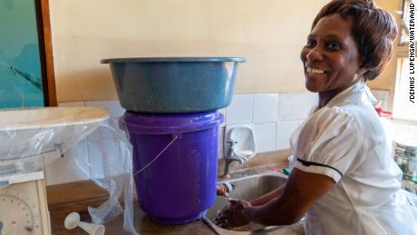 Patricia Mwenyeheri usa uno dei due lavandini nel centro sanitario dove lavora. 