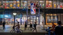 I pedoni superano il flagship store NBA a Pechino lo scorso ottobre.