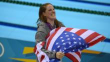 Franklin indossa una bandiera americana sul podio dopo aver ricevuto la sua medaglia d'oro per la finale di dorso di 100 metri femminile alle Olimpiadi di Londra 2012.