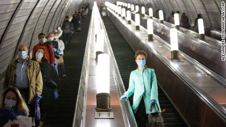La gente che indossa maschere e guanti su una scala mobile della metropolitana a Mosca martedì.