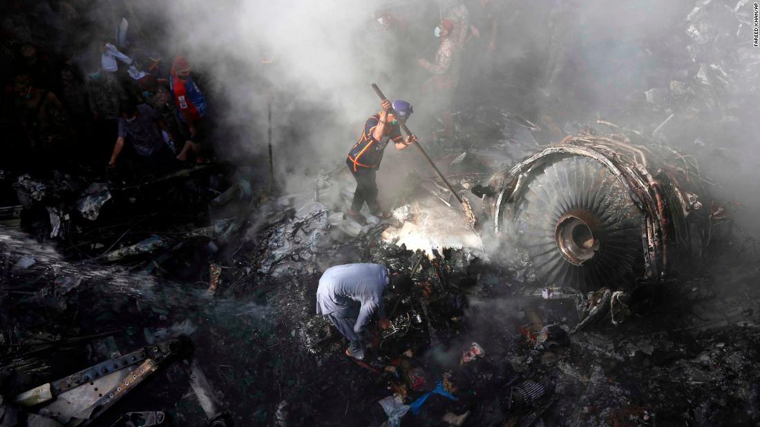 A firefighter sprays water on the wreckage of a Pakistan International Airlines aircraft after it crashed in a residential area in Karachi on Friday.