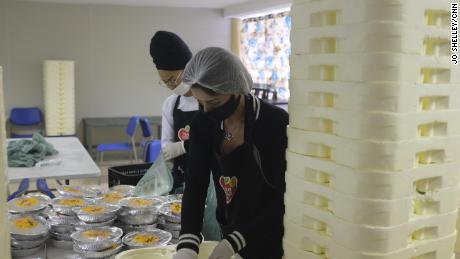 I volontari preparano alcuni dei 10.000 pasti che vengono distribuiti quotidianamente ai residenti della favela di Paraisopolis, quindi non devono lasciare le loro case per mangiare.