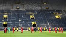 I giocatori osservano un minuto di silenzio per le vittime del coronavirus prima della partita di calcio della Bundesliga Premier League tedesca Borussia Dortmund e FC Bayern Monaco.