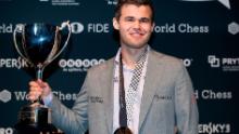 Carlsen detiene il suo trofeo dopo aver sconfitto Fabiano Caruana per riconquistare il titolo di campione del mondo di scacchi il 28 novembre 2018 a Londra.