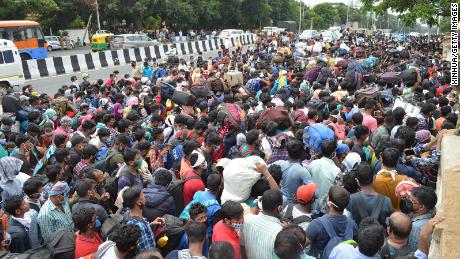 I lavoratori migranti attendono di salire a bordo degli autobus durante il blocco del coronavirus a Bangalore il 23 maggio 2023.  