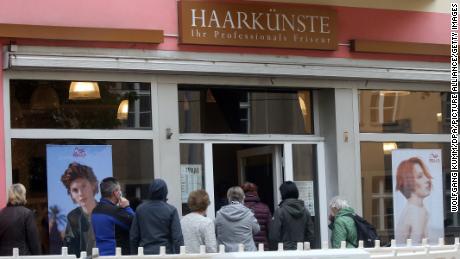 Una linea si forma lunedì in un salone a Berlino dopo la riapertura dei parrucchieri.