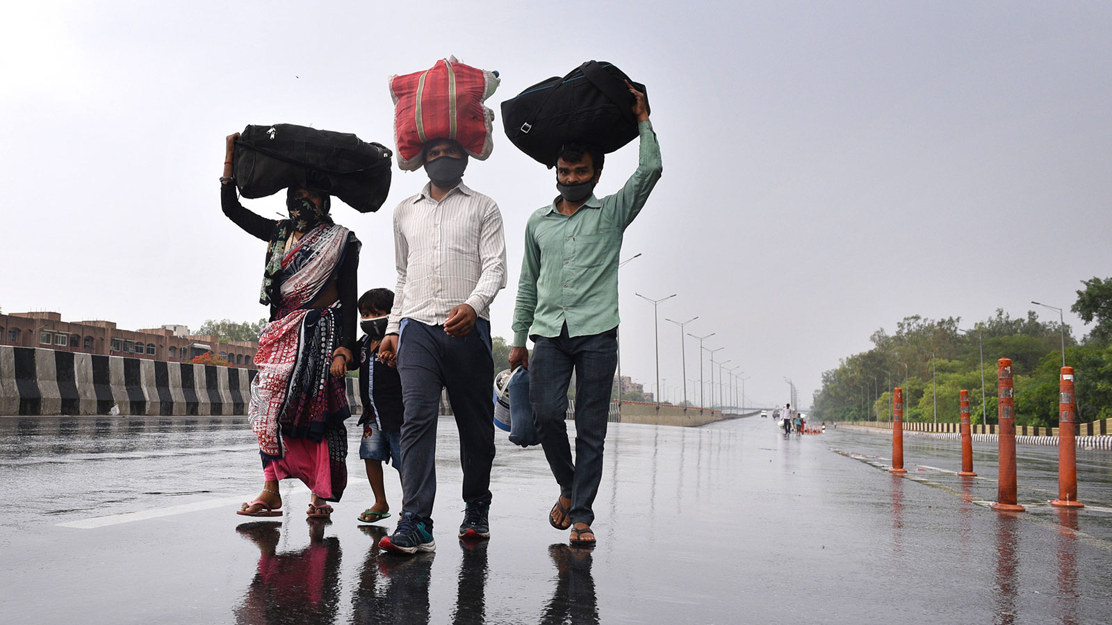 I lavoratori migranti si dirigono verso una fermata dell'autobus dopo aver appreso che l'amministrazione si sta preparando a riportare i lavoratori migranti nei loro paesi di origine durante l'isolamento a Nuova Delhi, in India, il 3 maggio. 