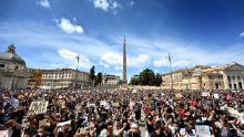 I manifestanti si inginocchiano con segni a Roma.