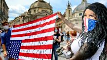 I manifestanti tengono una bandiera americana sottosopra a Roma.