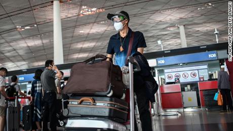 Un uomo che indossa una maschera e occhiali all'aeroporto internazionale di Pechino capitale il 17 giugno.