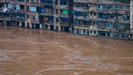 Il 1 ° luglio le acque alluvionali scorrono davanti a un edificio residenziale a Chongqing, nella Cina sud-occidentale.