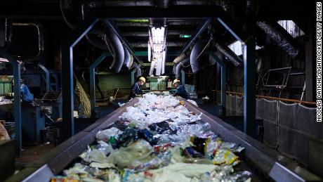 I lavoratori selezionano i rifiuti di plastica usa e getta su un nastro trasportatore presso il centro di riciclaggio Ichikawa Kankyo Engineering. L'ufficio della città di Katsushika a Tokyo porta ogni giorno circa 10 tonnellate di plastica riciclabile nell'impianto di riciclaggio.