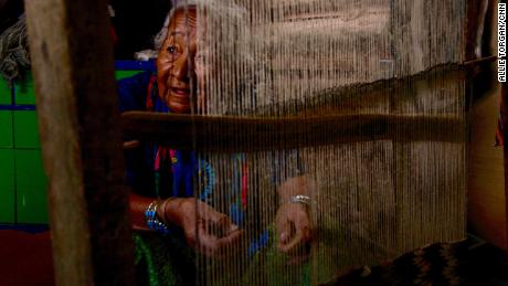 Marie Nez weaves a rug in her home on Navajo Nation.