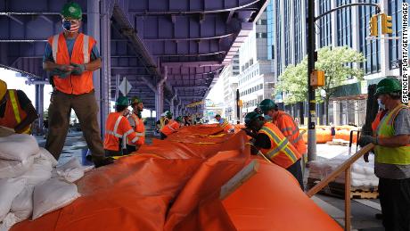 I lavoratori di New York stanno erigendo barriere contro le alluvioni per proteggersi da un'ondata di tempesta prevista.