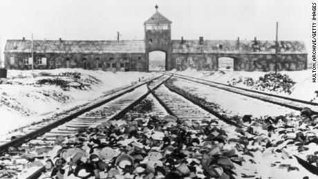 Gli effetti personali innevati di quelli deportati nel campo di concentramento di Auschwitz sporcano i binari del treno che conducono all'ingresso del campo, in un'immagine risalente al 1945 circa. 